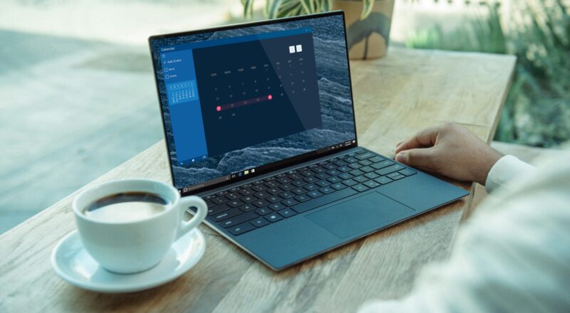 person using black laptop computer on brown wooden table